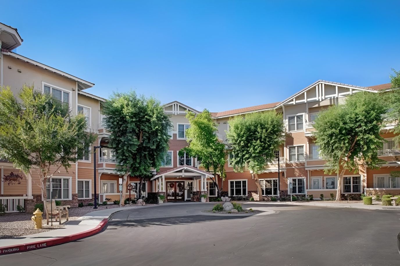 Front exterior view of the assisted living facility surrounded by greenery