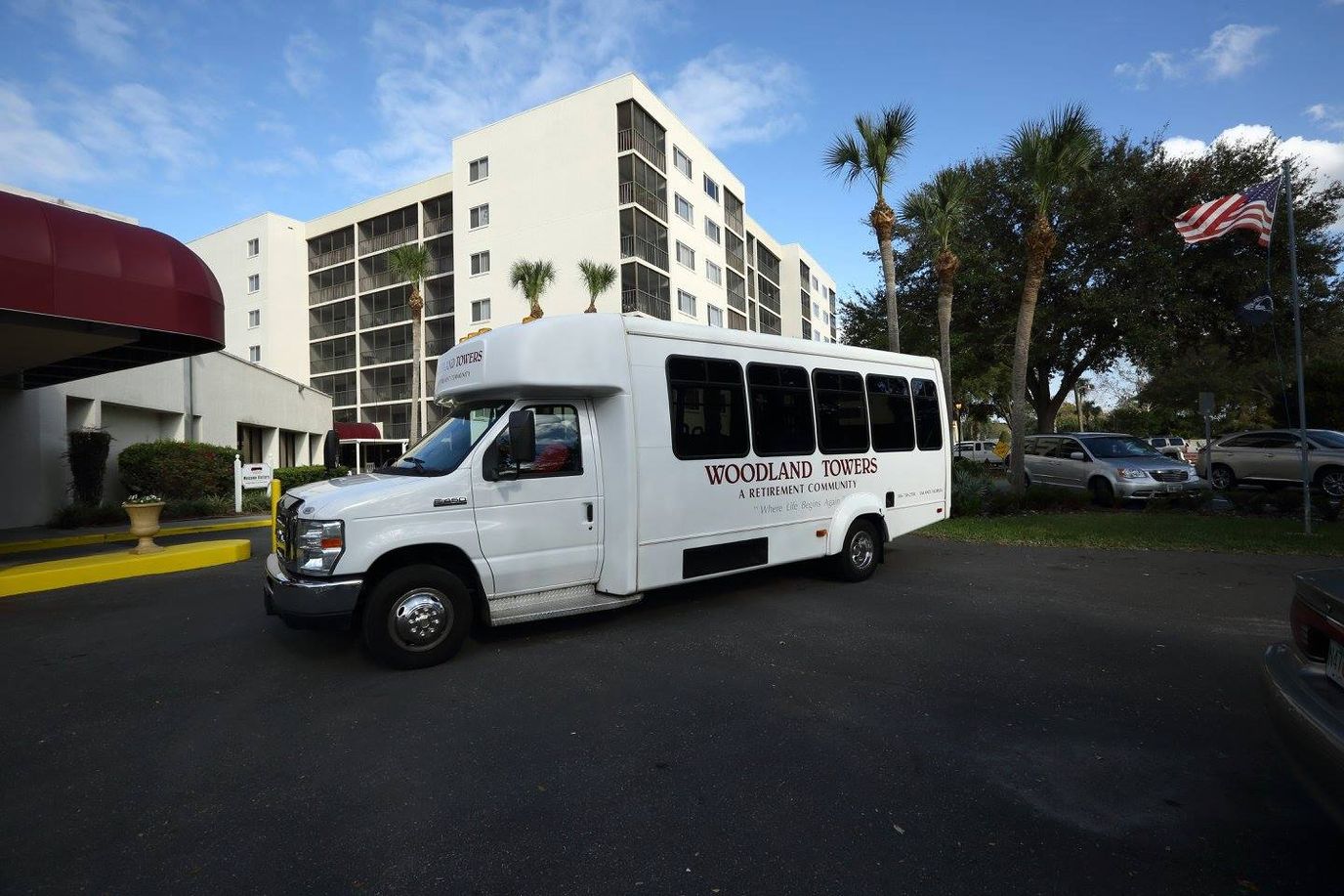 Facility transport van in front of Woodland Towers