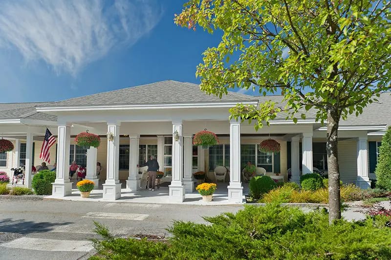 Front entrance of Woodlands Assisted Living with outdoor seating