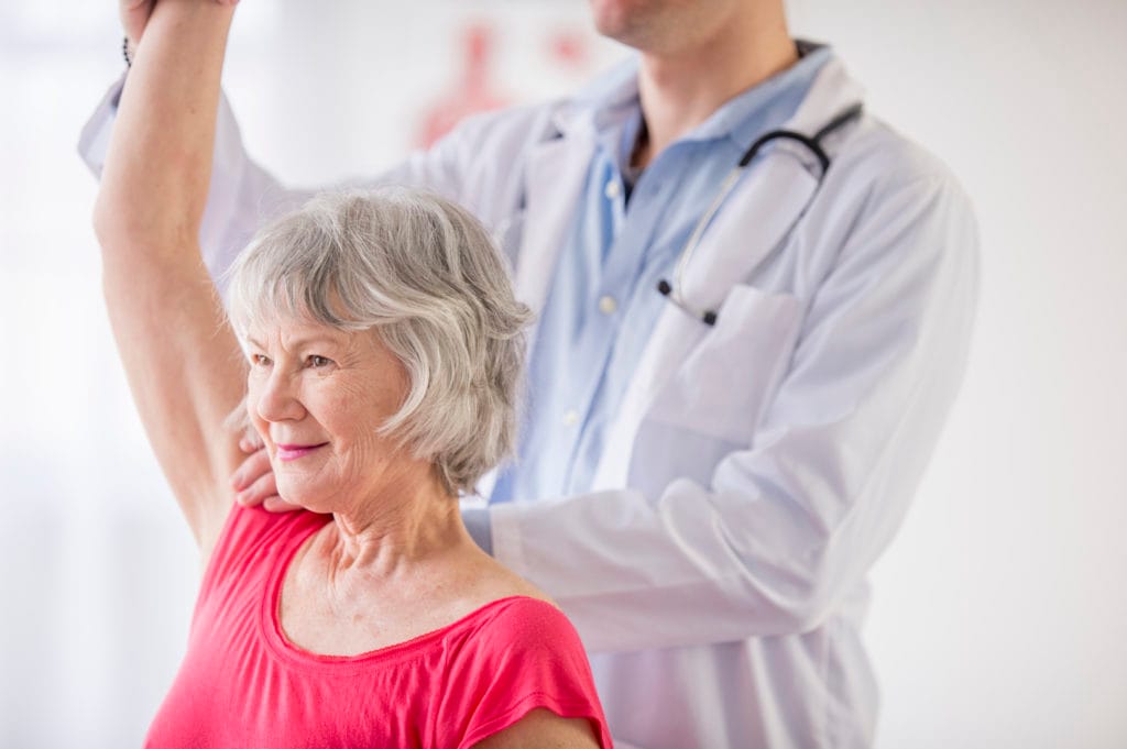 Senior woman receiving physical therapy from doctor