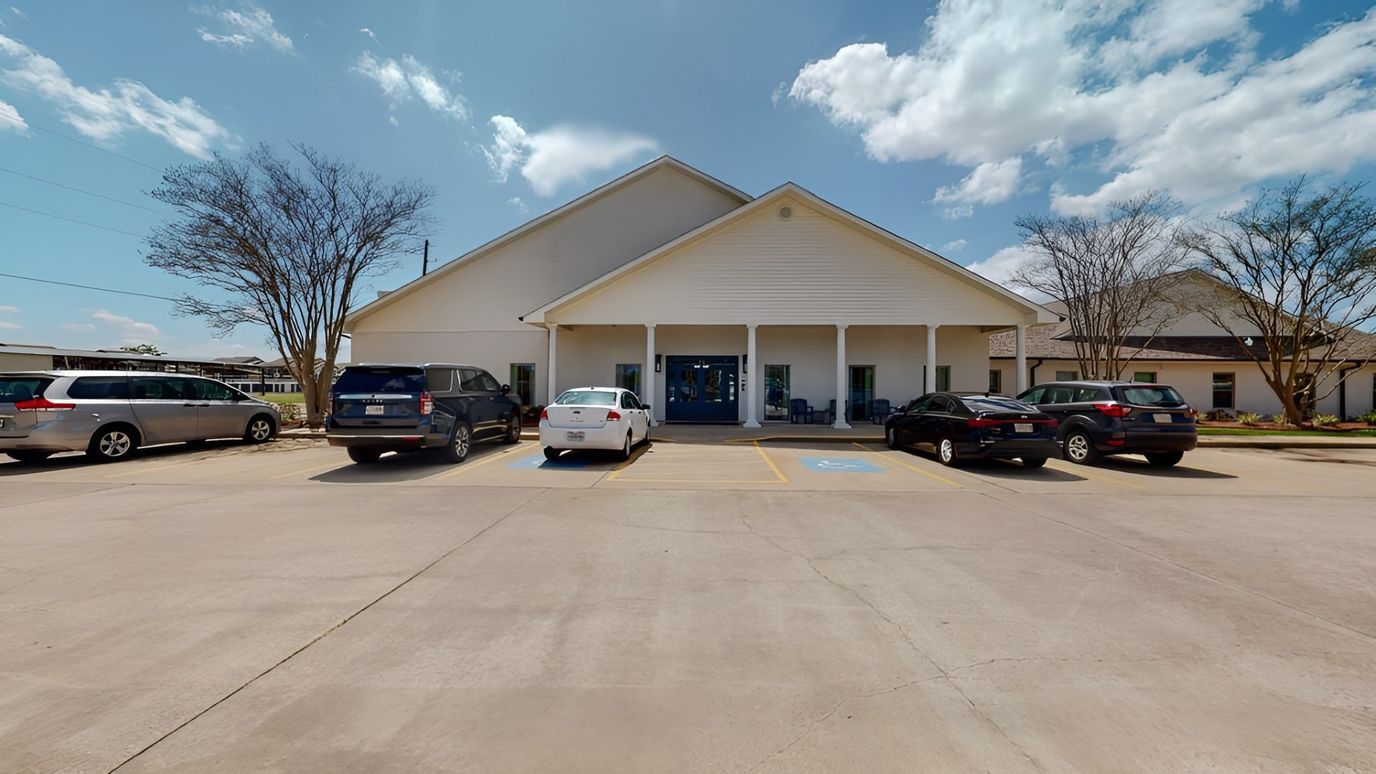 Front entrance of Guardian House facility with parking area