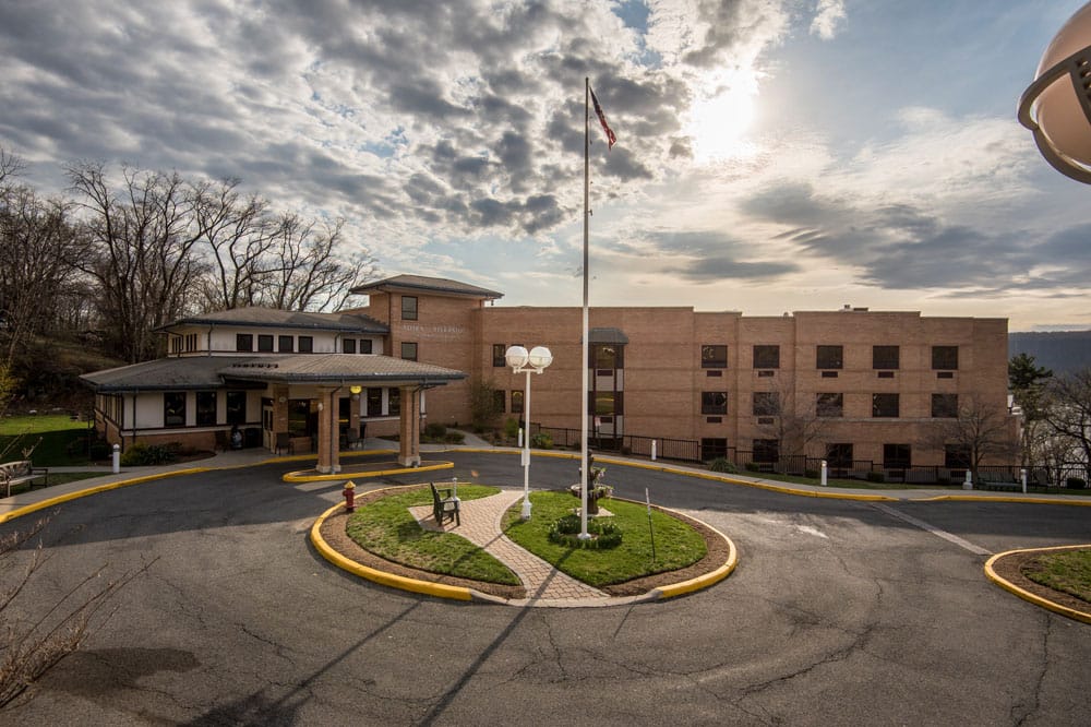 Exterior view of a senior living facility with garden and drive