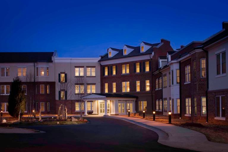 Exterior view of Arbor Acres at dusk with lighting