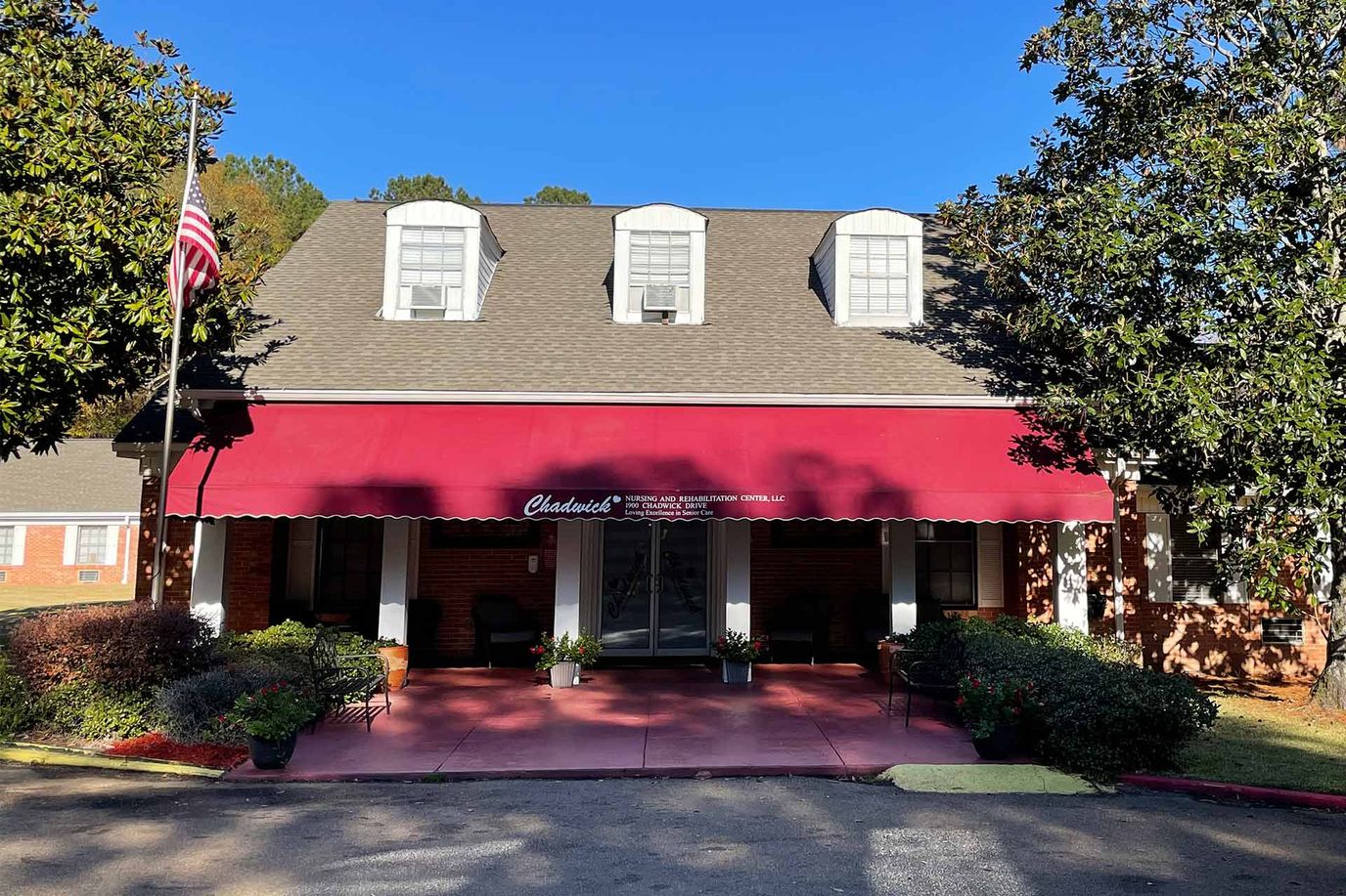 Exterior view of a senior living facility with a red awning