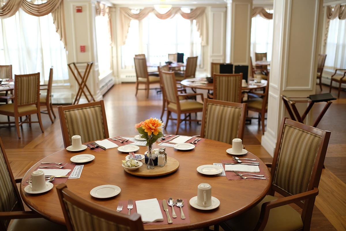 Dining room set up for a meal with fresh flowers.