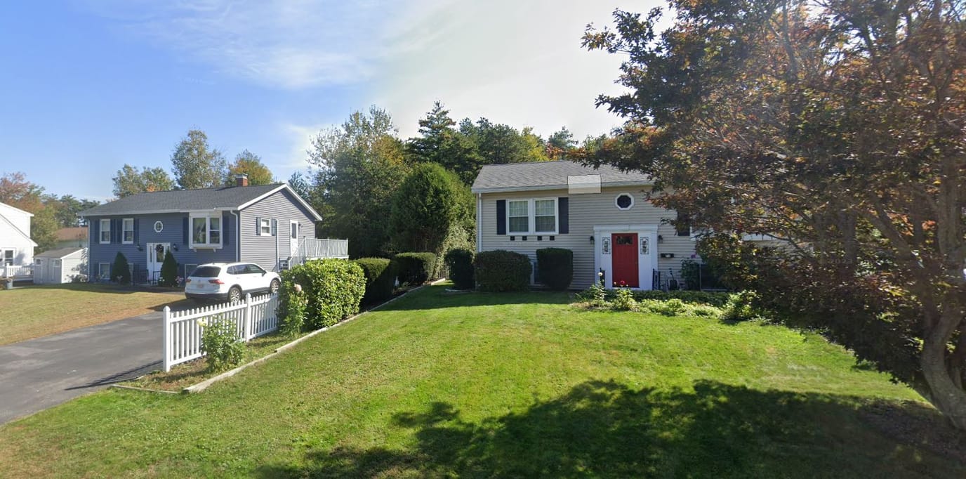 Exterior view of two well-kept houses in a green space