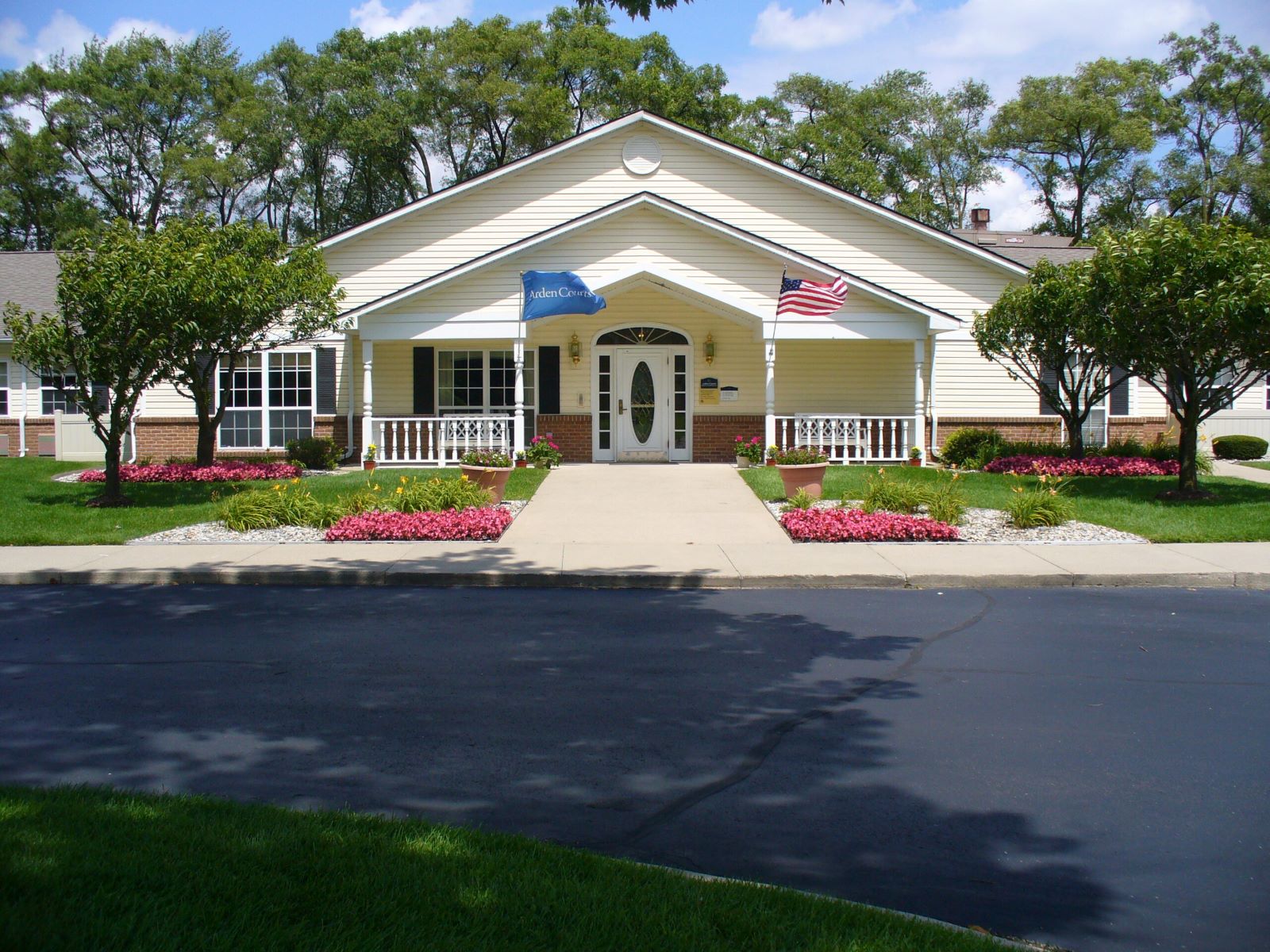 Front view of a senior living facility with gardens