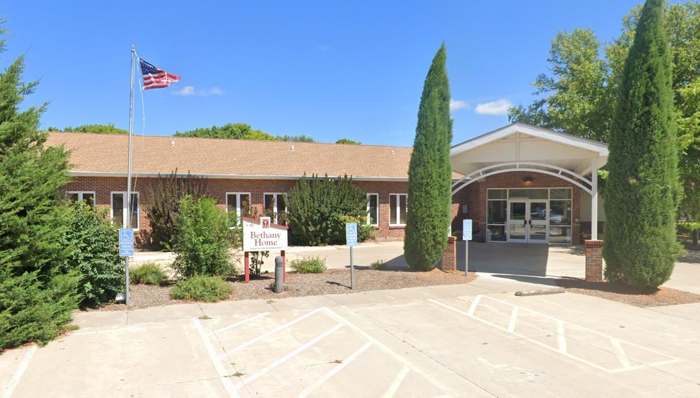 Front entrance of Bethany Home with flag and greenery