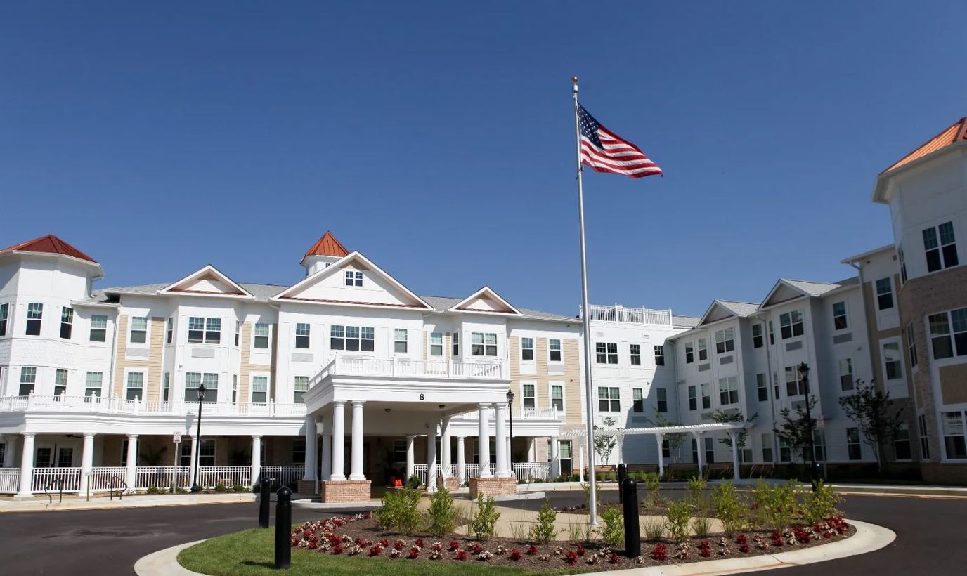 Exterior view of a senior living facility with flag