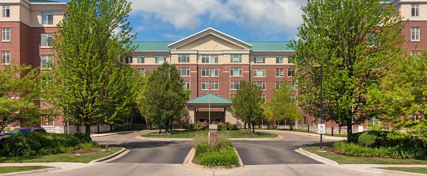 Exterior view of a senior living facility surrounded by trees