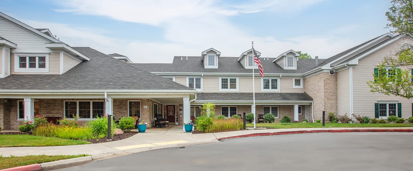 Exterior view of a senior living facility with gardens