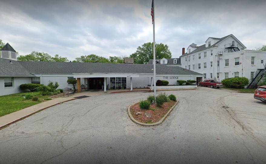 Exterior view of Candlelight Lodge with entrance and flagpole
