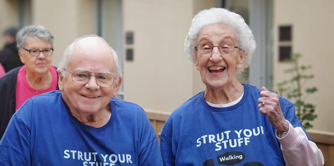 Two residents participating in a walking event wearing matching shirts
