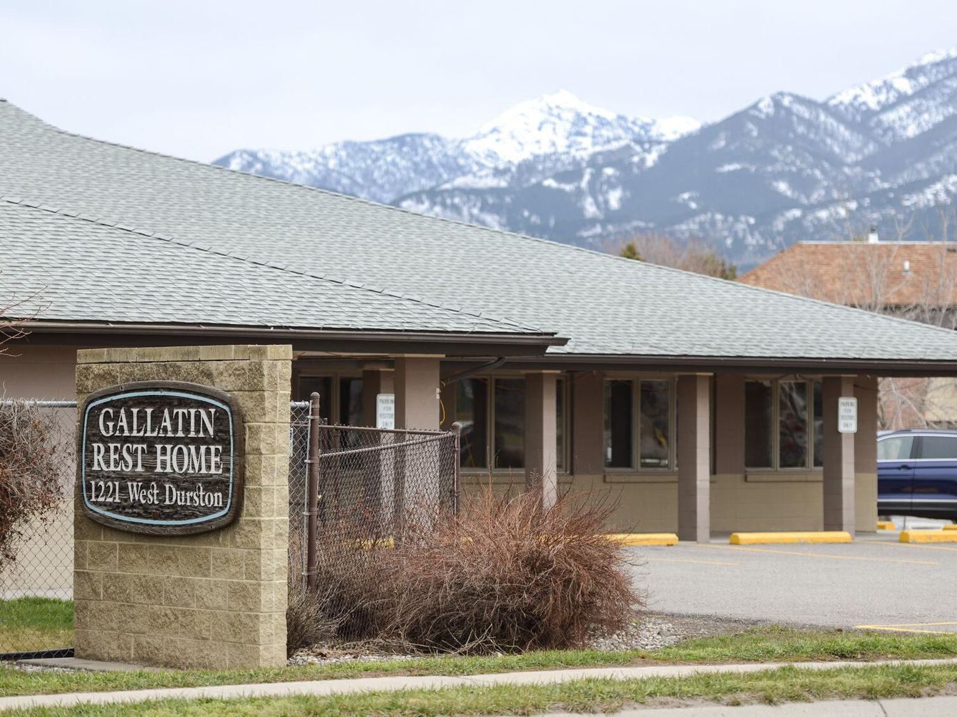 Exterior view of Gallatin Rest Home with mountains in the background