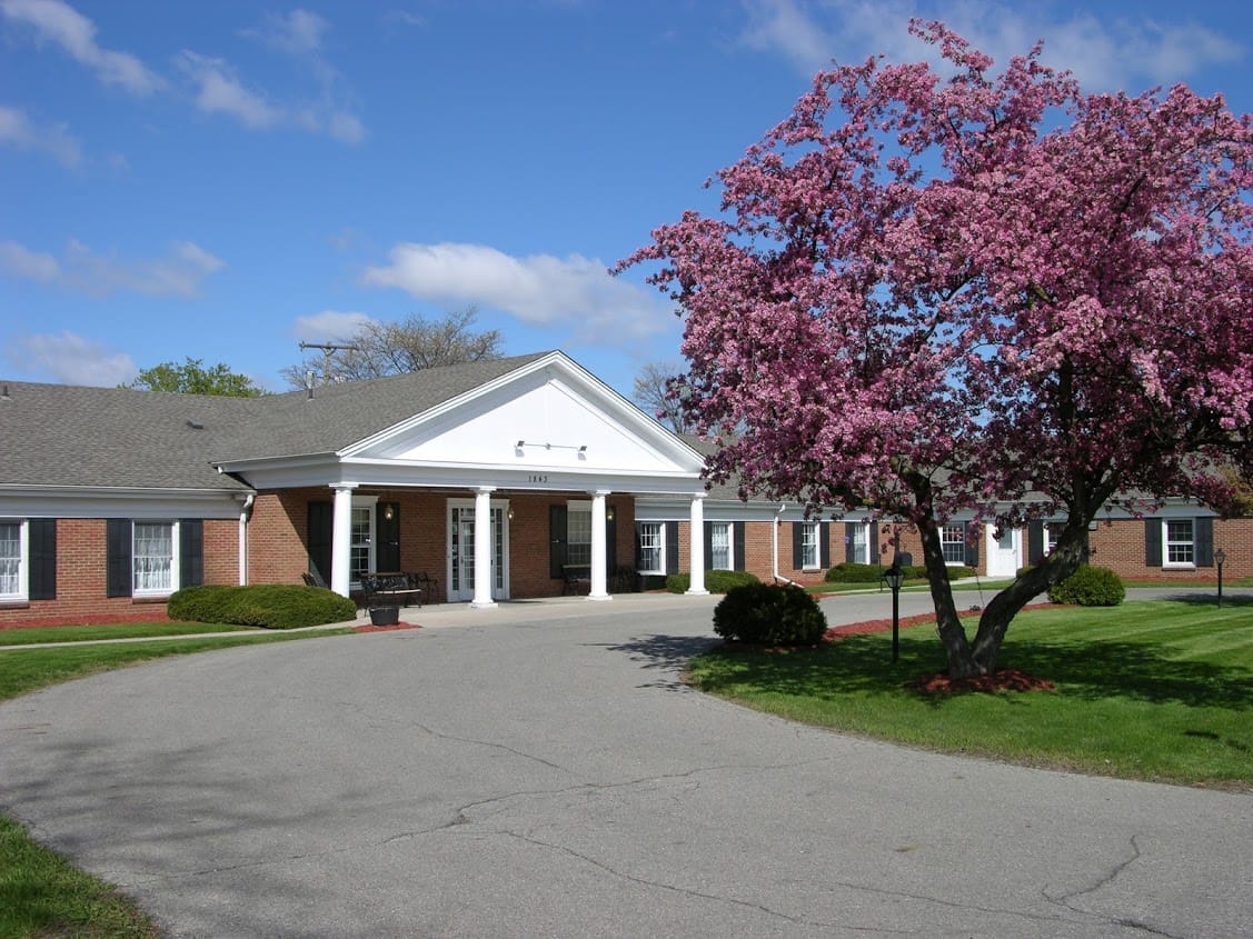 Exterior view of Medilodge of East Lansing with blooming tree