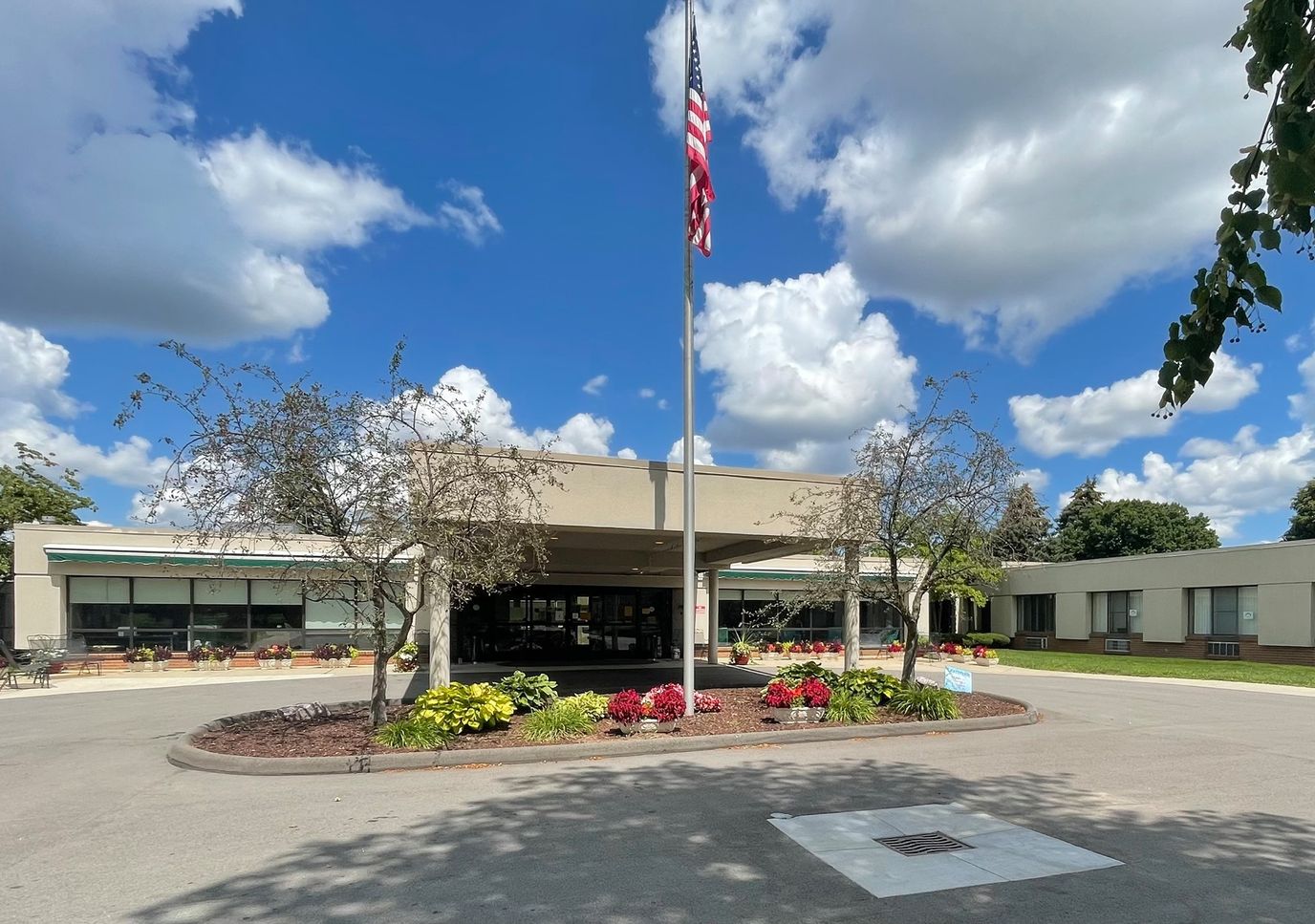 Front entrance of Medilodge of Sterling Heights with flowers