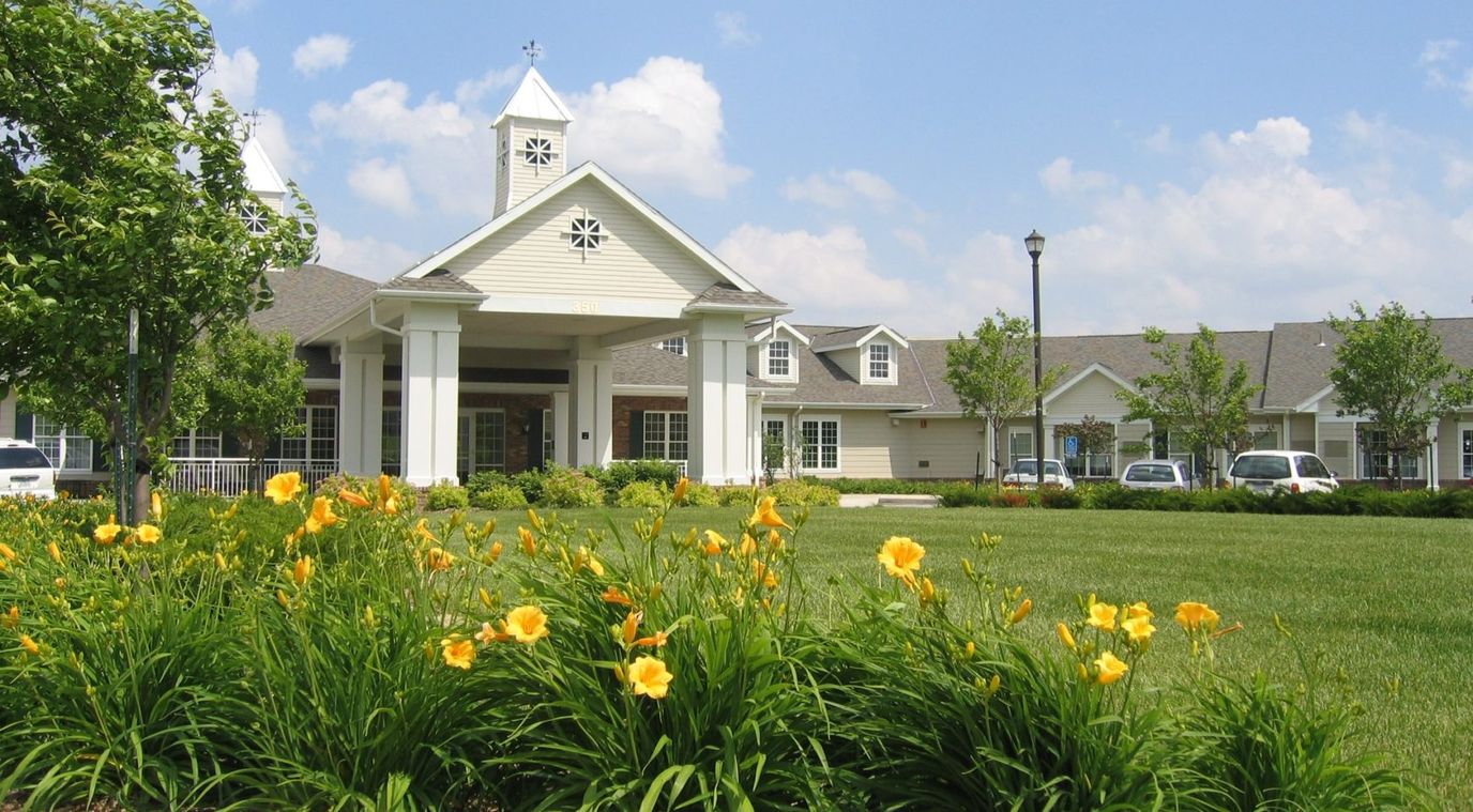 Exterior view of Melrose Meadows Retirement Community with flowers