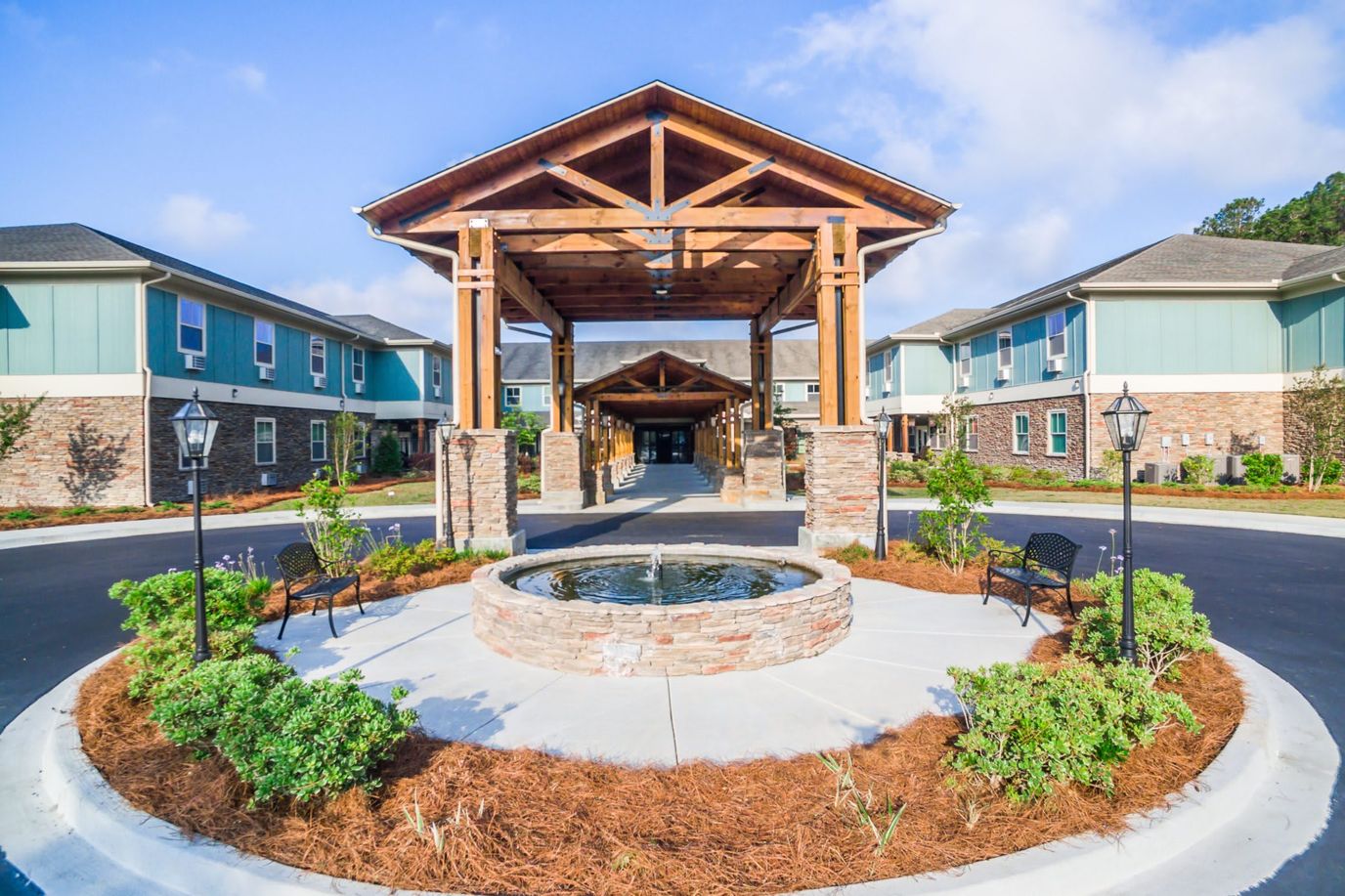 Exterior entrance of a senior living facility with landscaping