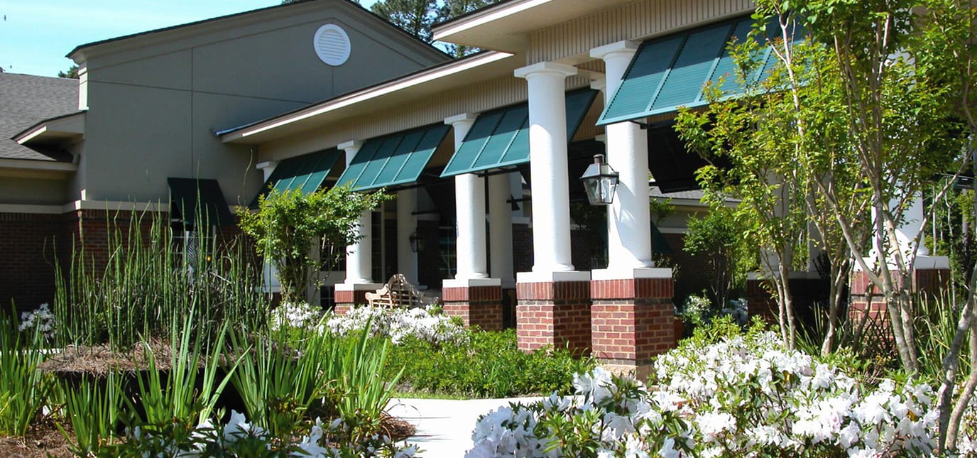 Exterior view of a nursing home with gardens and columns