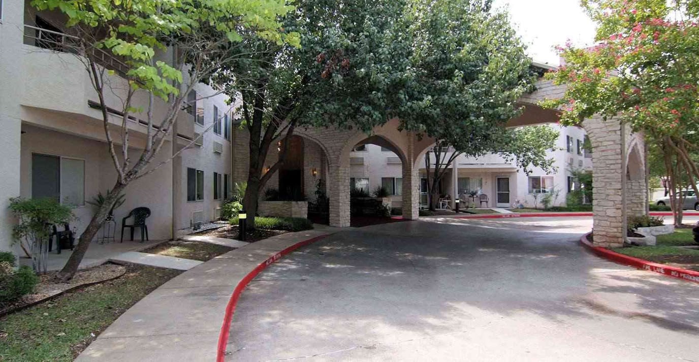 Entrance area with trees and pathway at senior living facility