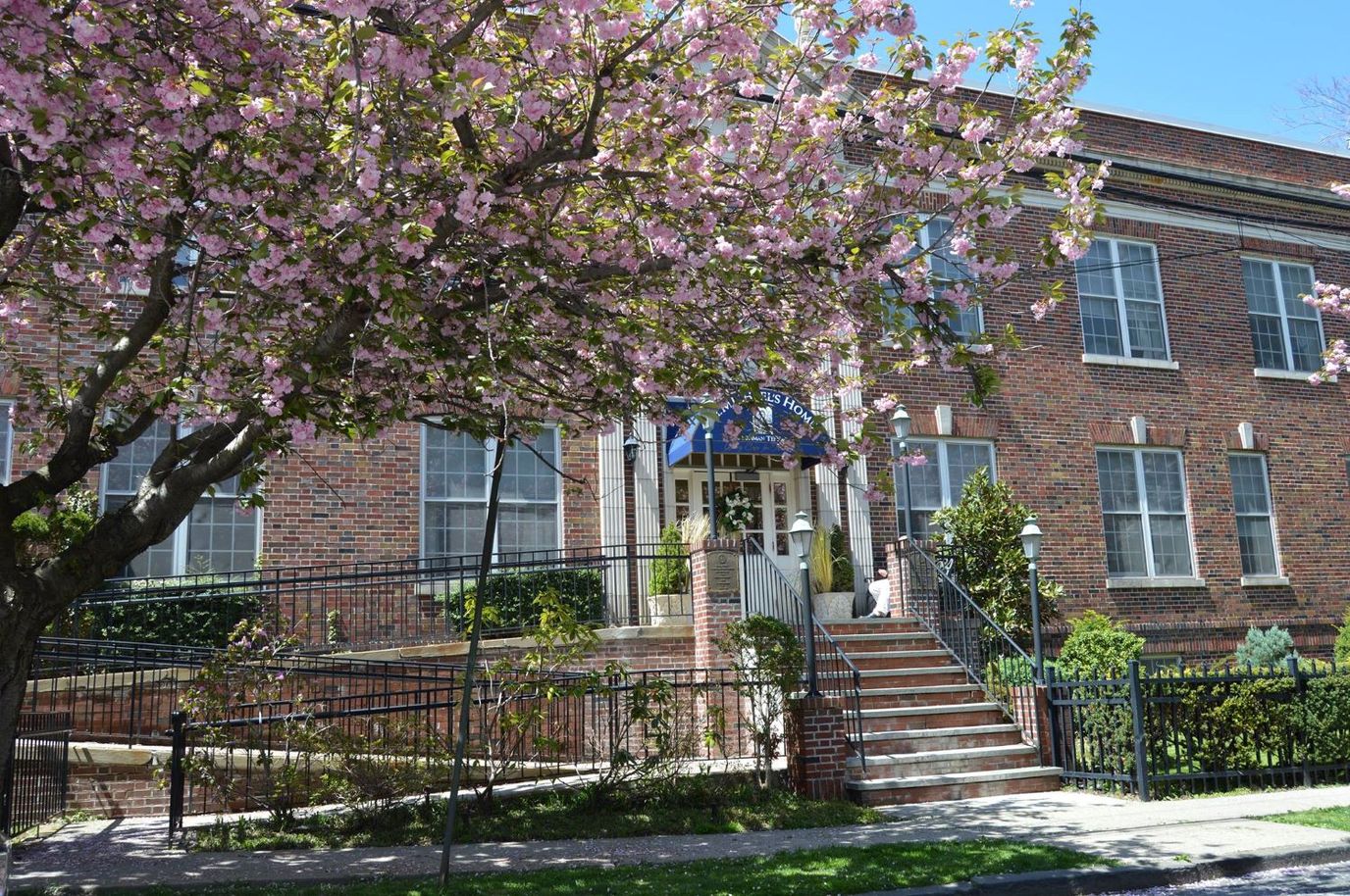 Exterior view of St Michael's Home surrounded by blooming trees