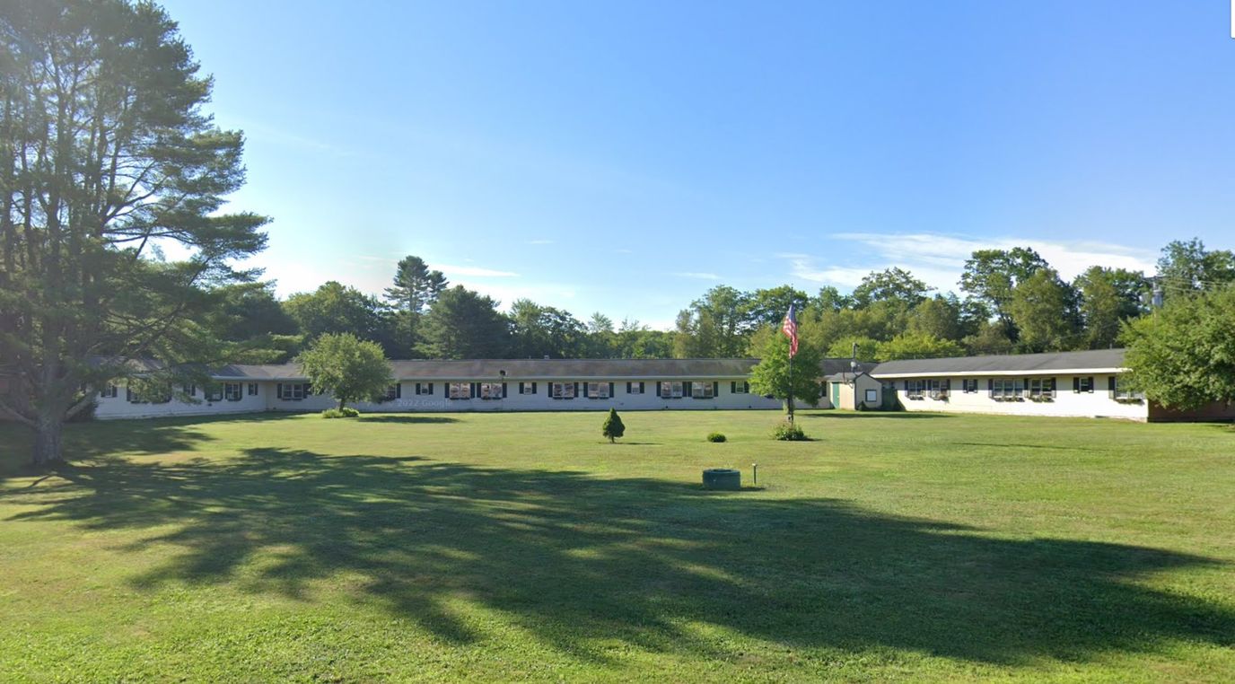 Exterior view of a senior living facility with green grass