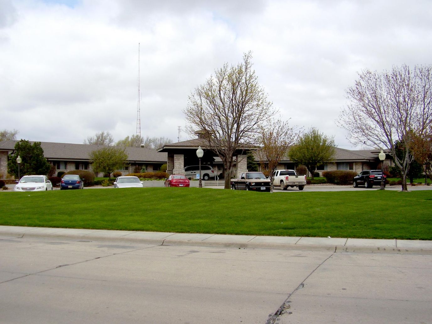 Exterior view of Tiffany Square Care Center with cars parked