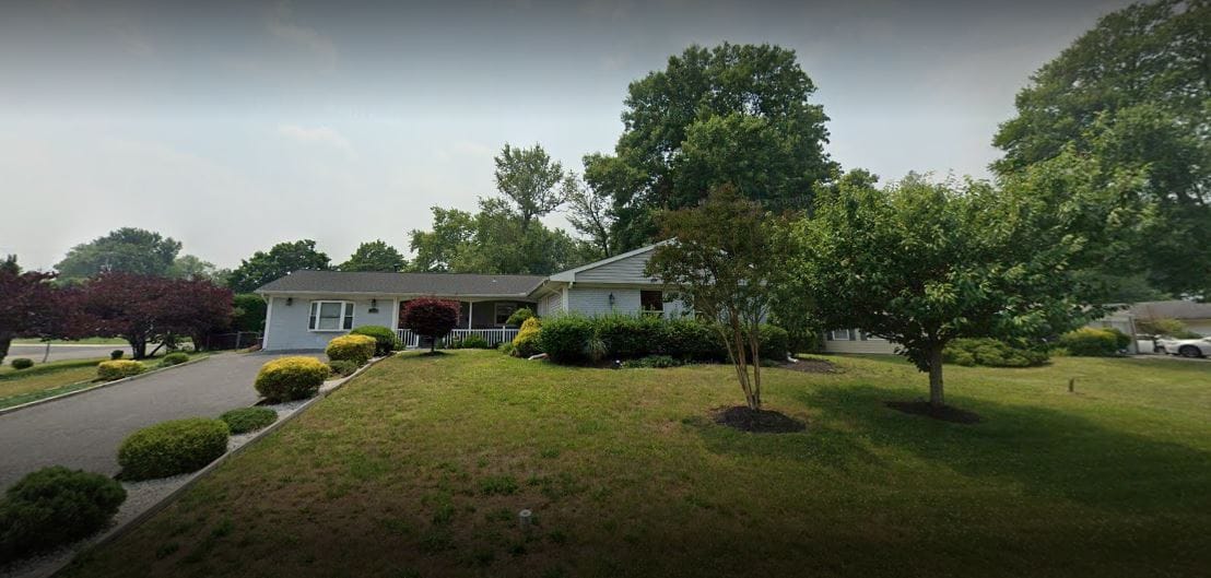 Exterior view of a senior living home with landscaped yard