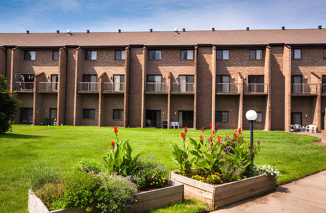 Exterior view of Brookwood Retirement Community with gardens