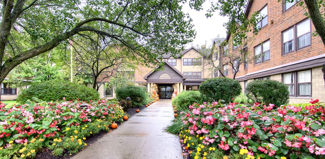 Exterior view of The Gables of Brighton with flower beds