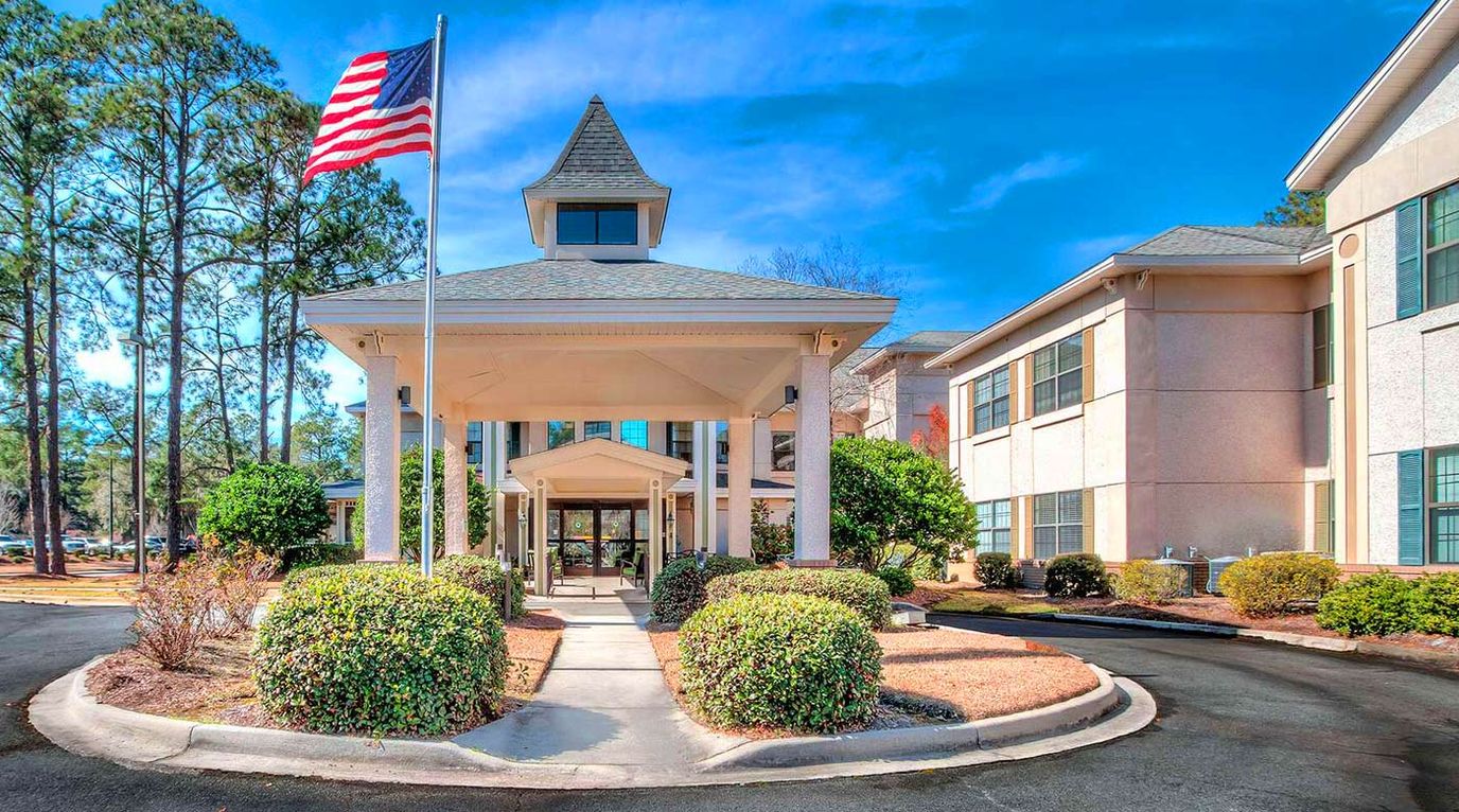 Front entrance of Oaks at Habersham with flag