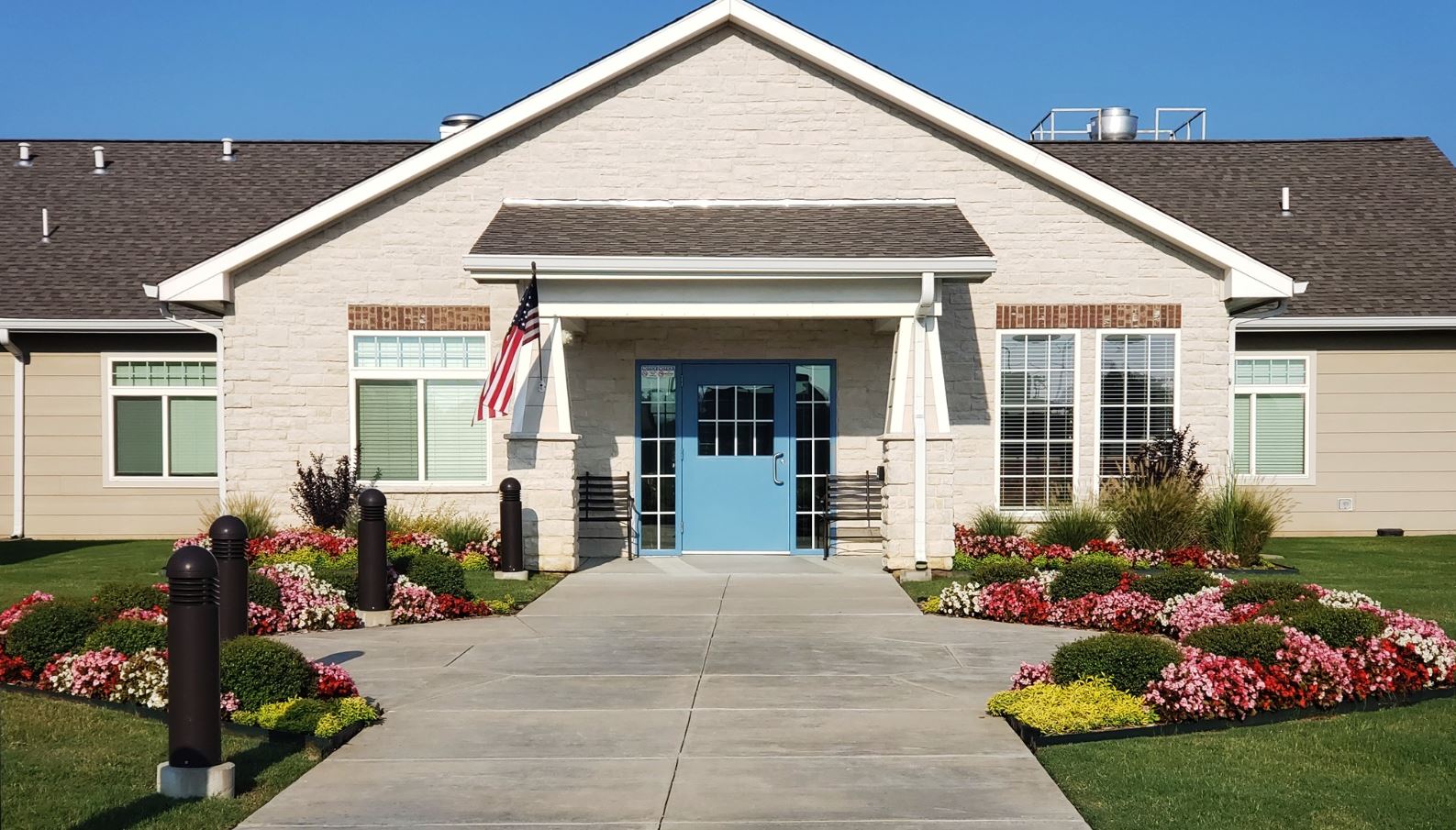 Front entrance of a senior care facility with landscaped flowers