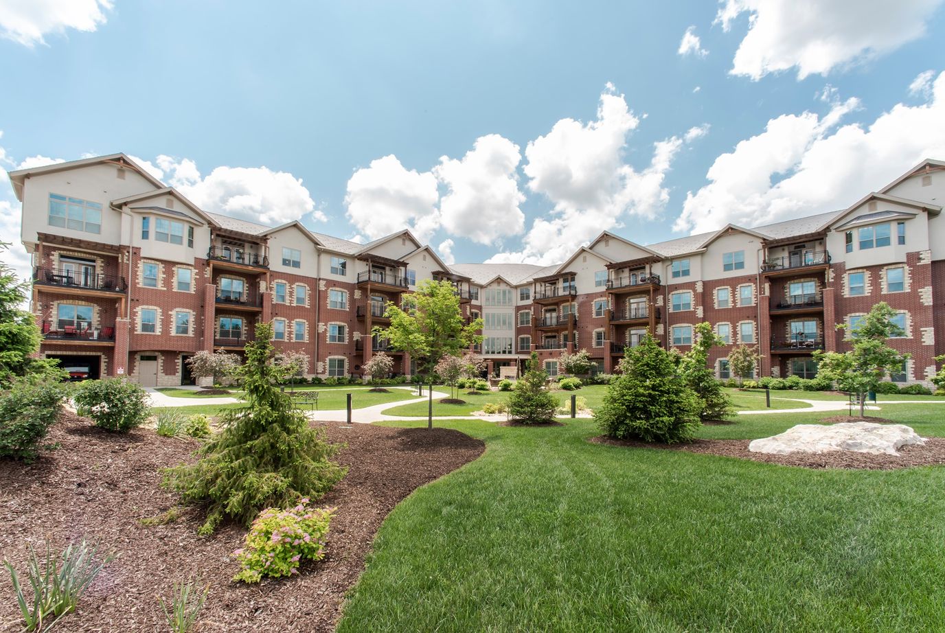 Exterior view of a senior living community with landscaped gardens