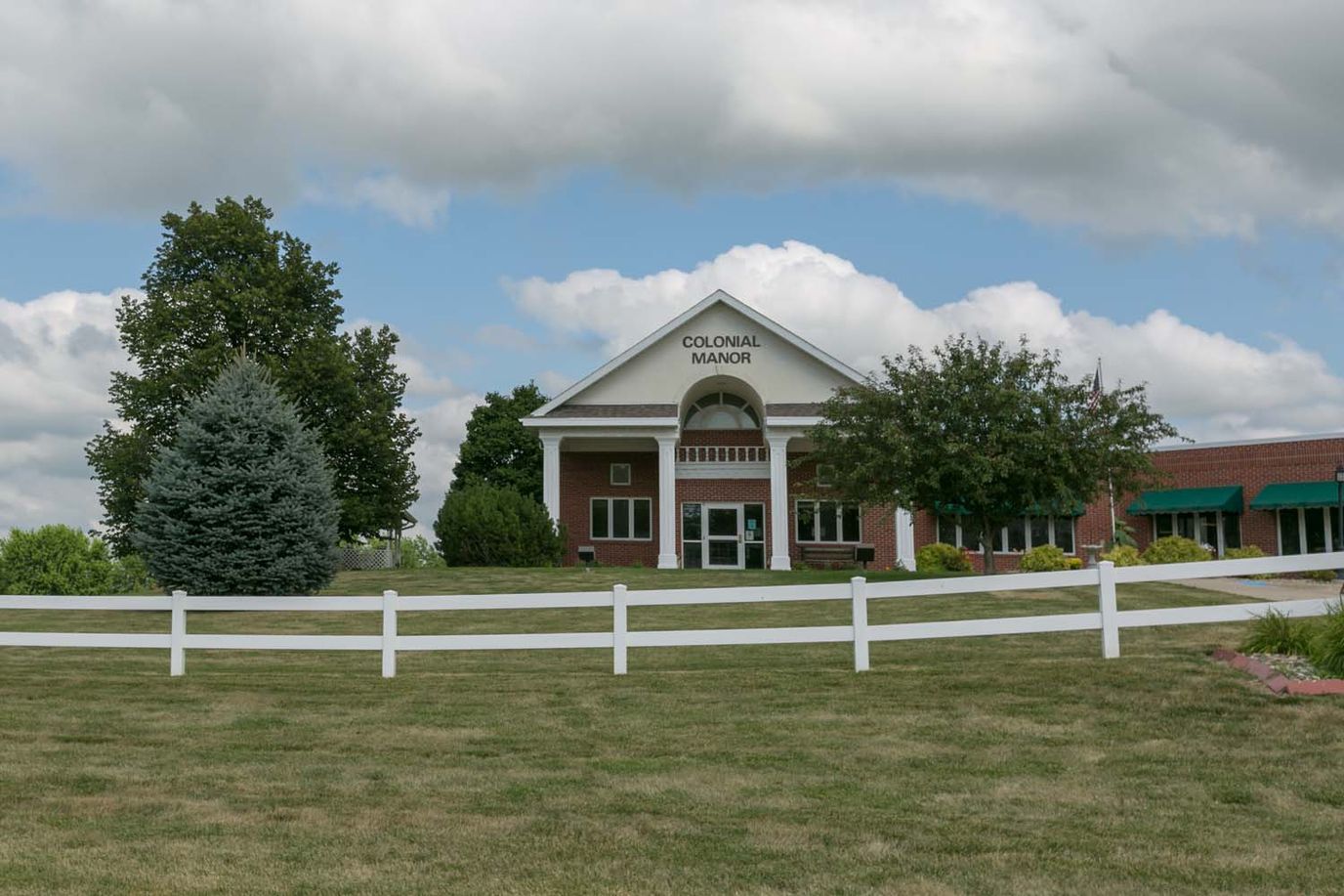 Exterior view of Colonial Manor with cloudy sky