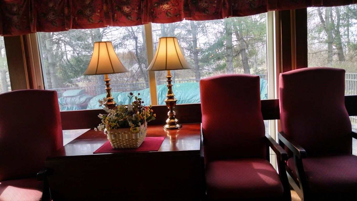 A well-lit living room with two lamps and a floral arrangement.