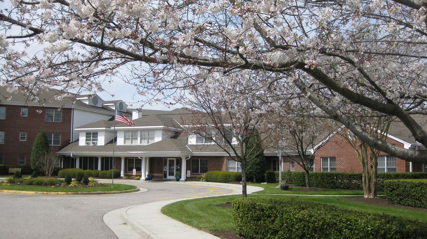 Exterior view of a senior living facility with flowering trees