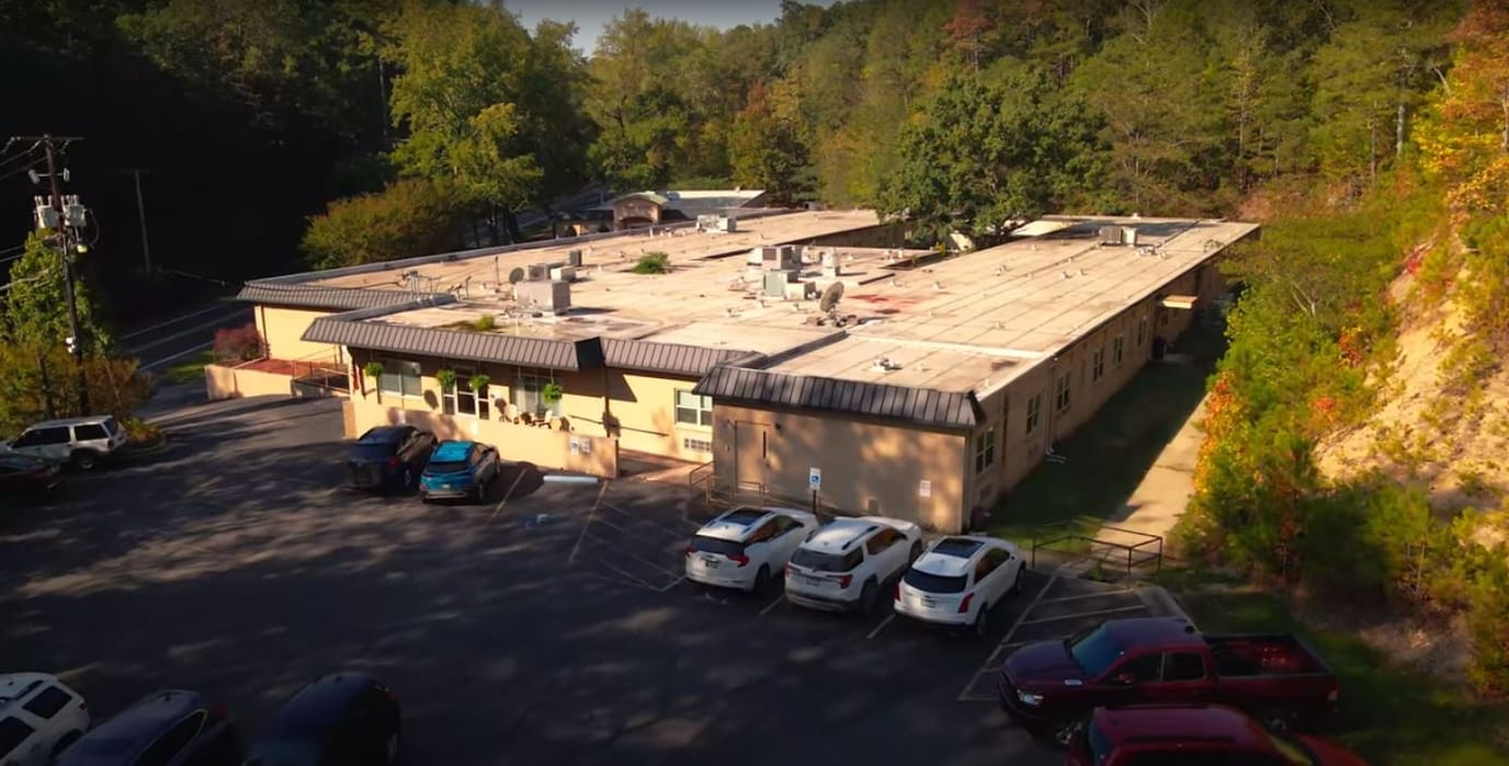 Aerial view of the facility building surrounded by trees