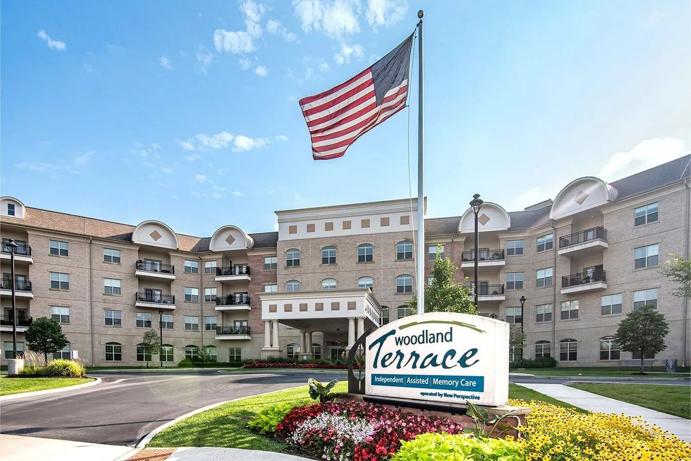 Exterior view of Woodland Terrace with flag and flowers