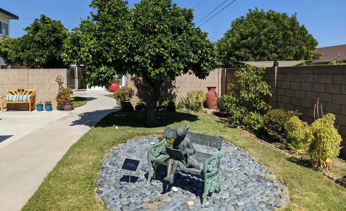 A serene outdoor garden with a statue and seating