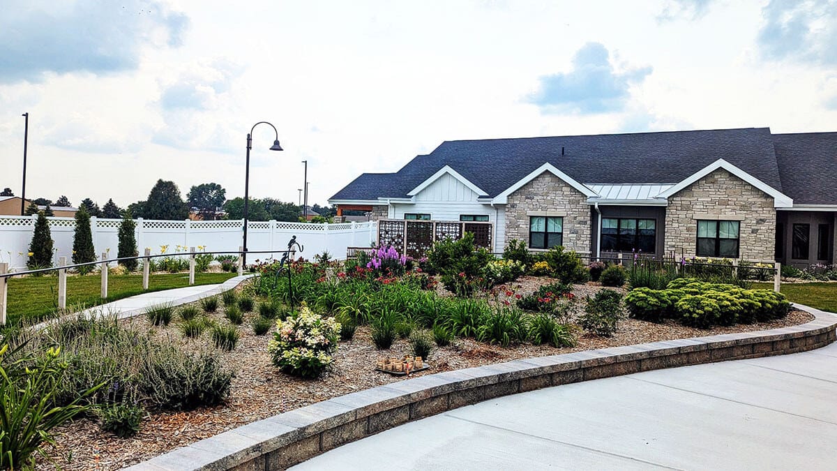 Exterior view of a senior living facility with gardens