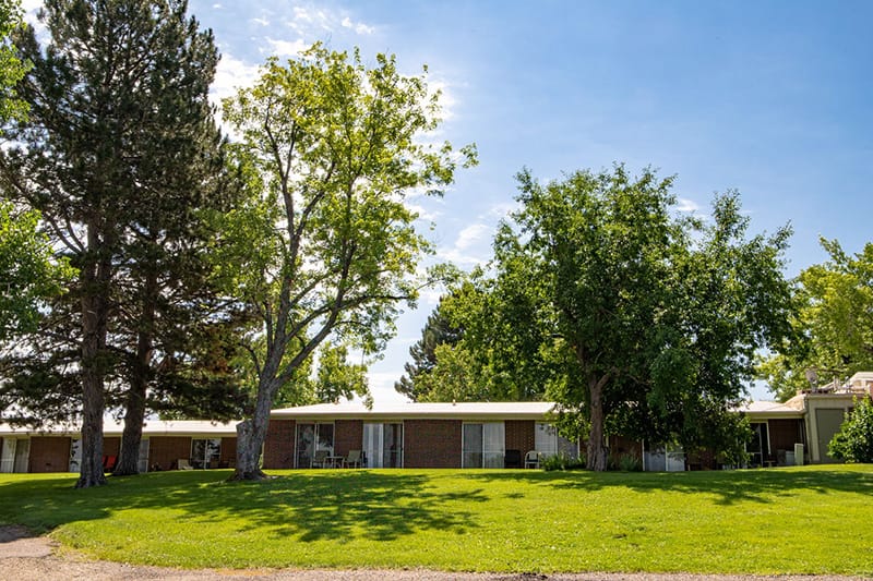 Exterior view of a senior living facility with trees