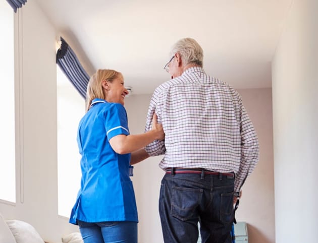 Caregiver assisting a senior resident indoors