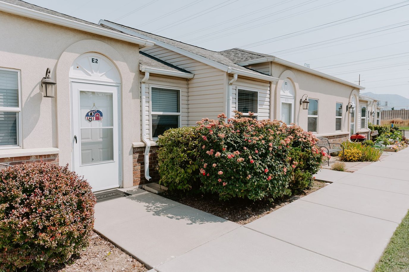 Exterior view of a senior living facility with landscaped flowers