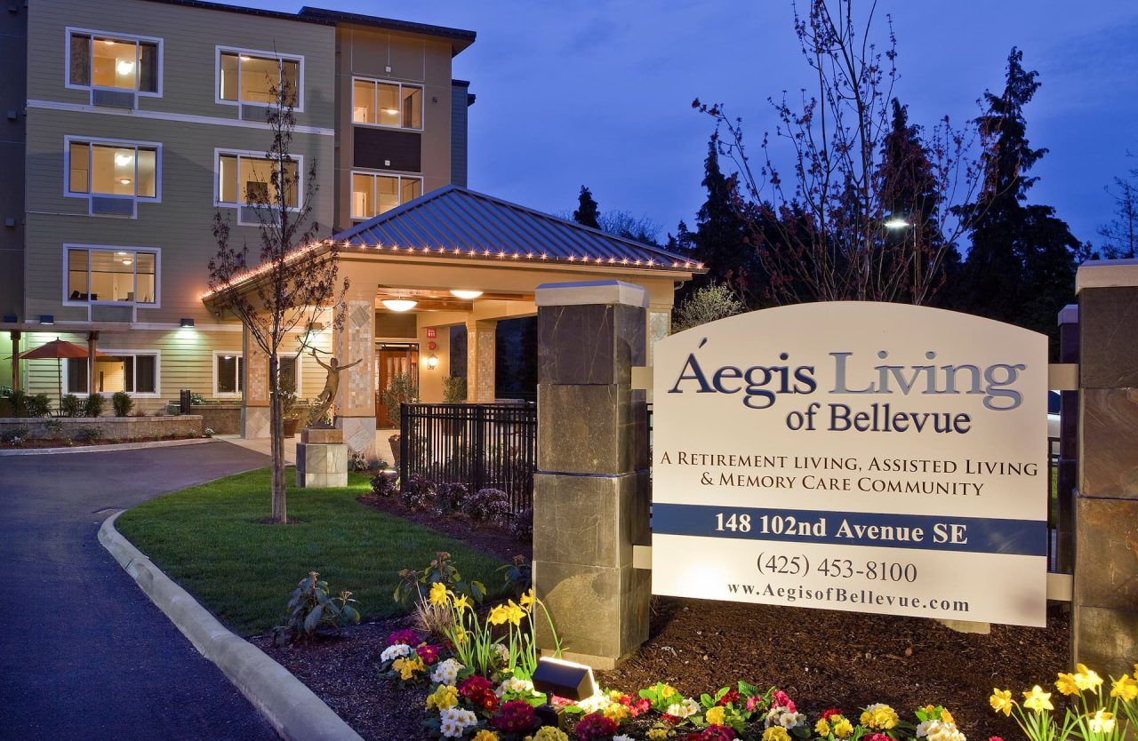 Exterior view of Aegis Living facility entrance at dusk