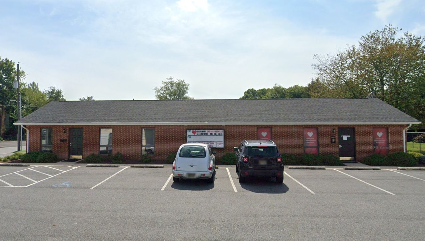 Exterior view of a nursing home facility with parked cars