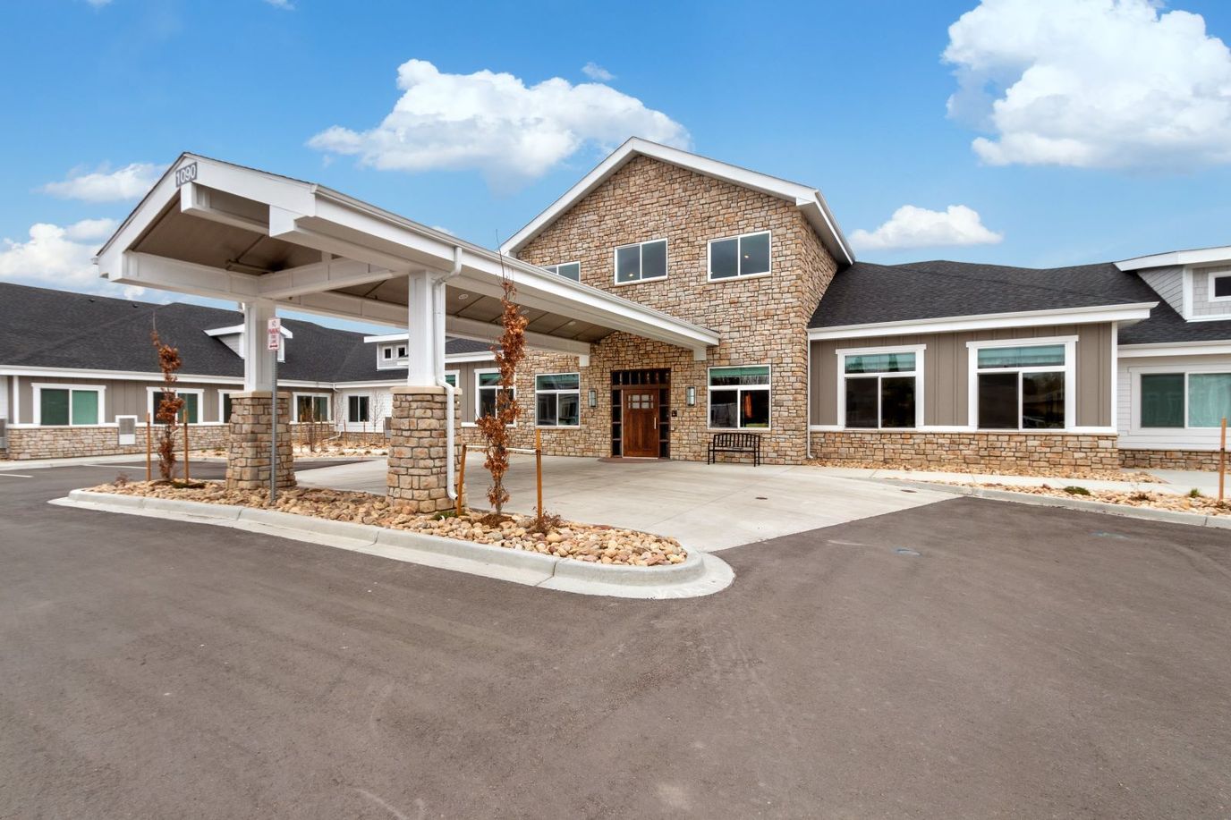 Exterior view of a senior living facility with stone facade