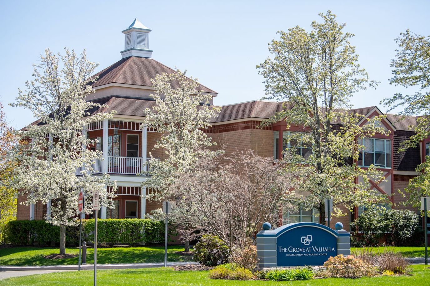 Exterior view of The Grove at Valhalla with spring flowers
