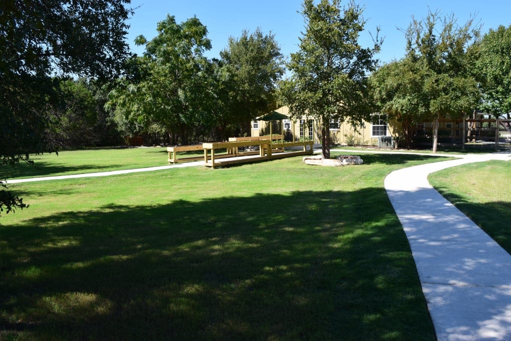 Outdoor pathway leading to a facility with greenery