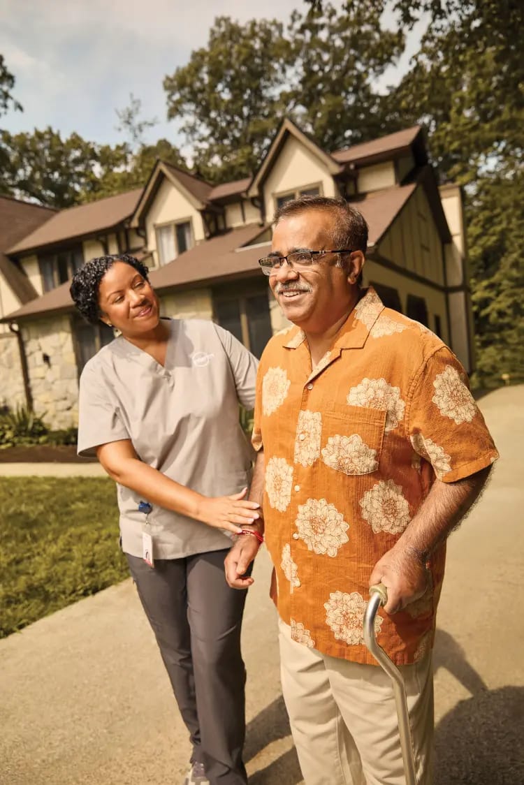 Caregiver assisting a resident outside a facility