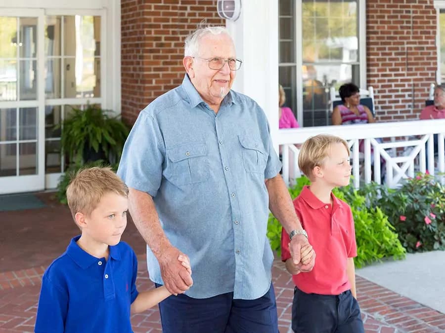 Senior resident walking outdoors with children